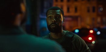 Movie still from “Charm City Kings” (2020), directed by Angel Manuel Soto – A person with a beard looking at the camera; Close Up shot, Over the shoulder angle