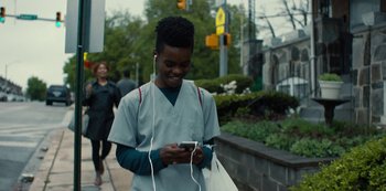 Movie still from “Charm City Kings” (2020), directed by Angel Manuel Soto – A young man is listening to music on his cell phone; Medium shot, Low angle