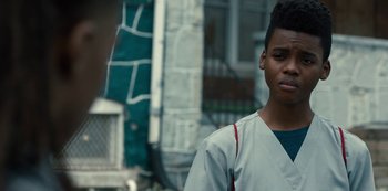 Movie still from “Charm City Kings” (2020), directed by Angel Manuel Soto – A young man standing in front of a building; Close Up shot, Over the shoulder angle