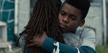 Movie still from “Charm City Kings” (2020), directed by Angel Manuel Soto – A young boy is hugging another young person; Close Up shot, Over the shoulder angle