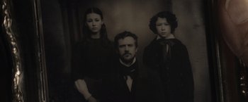A black and white photo of a man and two women