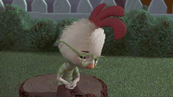Movie still from “Chicken Little” (2005), directed by Mark Dindal – A cartoon chicken wearing a pair of eyeglasses and sitting on top of a tree stump; Medium shot, High angle