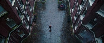 Movie still from “Child's Play” (2019), directed by Lars Klevberg – An overhead view of a person walking in the rain with an umbrella; Extreme Wide shot, Overhead angle