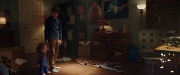 Movie still from “Child's Play” (2019), directed by Lars Klevberg – A young man standing in a room with a bunch of papers on the floor; Wide shot, High angle