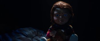 Movie still from “Child's Play” (2019), directed by Lars Klevberg – A child's play doll with blue eyes holding a teddy bear; Close Up shot, Low angle