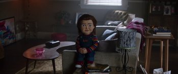 Movie still from “Child's Play” (2019), directed by Lars Klevberg – A chucky doll sitting on top of a couch; Medium shot, High angle