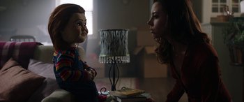 Movie still from “Child's Play” (2019), directed by Lars Klevberg – A woman is talking to a doll in a room; Medium shot, Over the shoulder angle