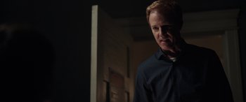 Movie still from “Child's Play” (2019), directed by Lars Klevberg – A man standing in a dark room with his mouth wide open; Close Up shot, Over the shoulder angle