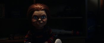 Movie still from “Child's Play” (2019), directed by Lars Klevberg – A chucky doll in a dark room; Close Up shot, Over the shoulder angle