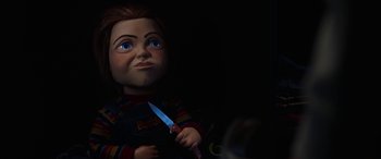 Movie still from “Child's Play” (2019), directed by Lars Klevberg – A child's play doll holding a knive in a dark room; Close Up shot, High angle