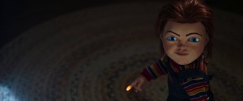 Movie still from “Child's Play” (2019), directed by Lars Klevberg – A doll holding something in his hand; Medium shot, High angle