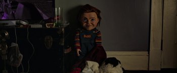 Movie still from “Child's Play” (2019), directed by Lars Klevberg – A chucky doll sitting on the floor next to a table; Medium shot, High angle