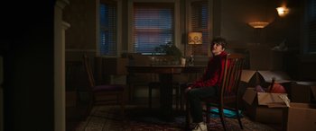 Movie still from “Child's Play” (2019), directed by Lars Klevberg – A boy sitting at a dining room table in the dark; Wide shot, Over the shoulder angle