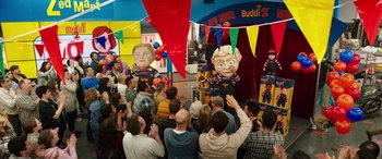 Movie still from “Child's Play” (2019), directed by Lars Klevberg – A group of people standing in front of a puppet show; Extreme Wide shot, High angle