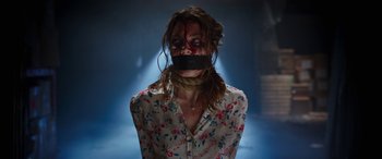 Movie still from “Child's Play” (2019), directed by Lars Klevberg – A woman with a mouth taped shut with blood all over her face; Close Up shot, Over the shoulder angle