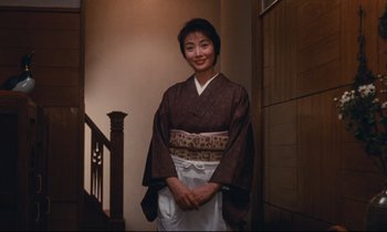 Movie still from “Chizuko's Younger Sister” (1991), directed by Nobuhiko Ôbayashi – A woman wearing a kimono standing in a doorway; Medium shot, Low angle