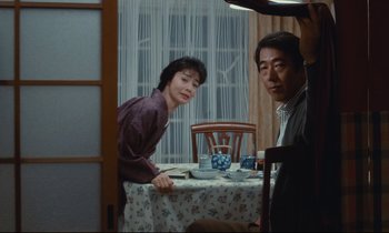 Movie still from “Chizuko's Younger Sister” (1991), directed by Nobuhiko Ôbayashi – A man and a woman sitting at a dinner table; Medium shot, Over the shoulder angle