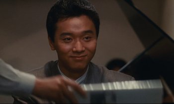 Movie still from “Chizuko's Younger Sister” (1991), directed by Nobuhiko Ôbayashi – A man sitting in front of a piano keyboard; Close Up shot, High angle
