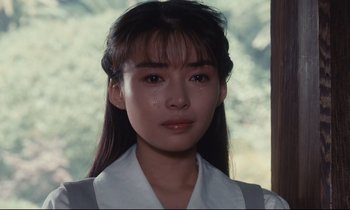 Movie still from “Chizuko's Younger Sister” (1991), directed by Nobuhiko Ôbayashi – A young woman with long black hair wearing a white shirt; Close Up shot, Over the shoulder angle