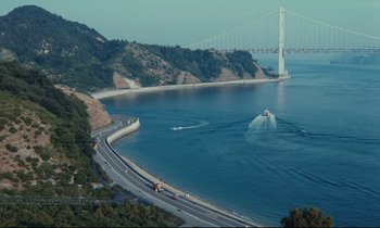 Movie still from “Chizuko's Younger Sister” (1991), directed by Nobuhiko Ôbayashi – A large body of water with a bridge in the background; Extreme Wide shot, High angle