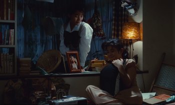 Movie still from “Chizuko's Younger Sister” (1991), directed by Nobuhiko Ôbayashi – A woman sitting in front of a mirror next to another woman; Medium shot, High angle