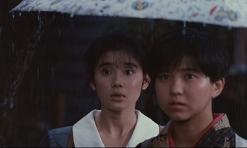 Movie still from “Chizuko's Younger Sister” (1991), directed by Nobuhiko Ôbayashi – Two young women standing under an umbrella in the rain; Close Up shot, Low angle