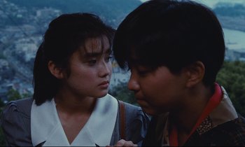 Movie still from “Chizuko's Younger Sister” (1991), directed by Nobuhiko Ôbayashi – A woman standing next to a man in a field; Close Up shot, Over the shoulder angle