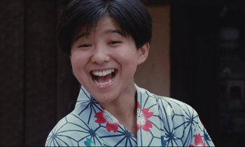 Movie still from “Chizuko's Younger Sister” (1991), directed by Nobuhiko Ôbayashi – A young person wearing a hawaiian shirt and smiling; Close Up shot, Low angle