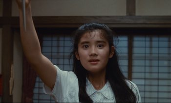 Movie still from “Chizuko's Younger Sister” (1991), directed by Nobuhiko Ôbayashi – A young woman in a white shirt raising her hand; Close Up shot, Low angle