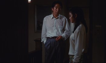 Movie still from “Chizuko's Younger Sister” (1991), directed by Nobuhiko Ôbayashi – A man and a woman standing next to each other in a room; Medium shot, Low angle