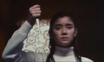 Movie still from “Chizuko's Younger Sister” (1991), directed by Nobuhiko Ôbayashi – A woman holding a knife in her hand; Medium shot, Low angle