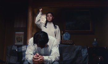 Movie still from “Chizuko's Younger Sister” (1991), directed by Nobuhiko Ôbayashi – A man and a woman sitting on a couch; Medium shot, Low angle