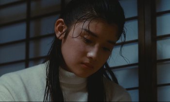 Movie still from “Chizuko's Younger Sister” (1991), directed by Nobuhiko Ôbayashi – A young woman with long hair and a white sweater; Close Up shot, Low angle