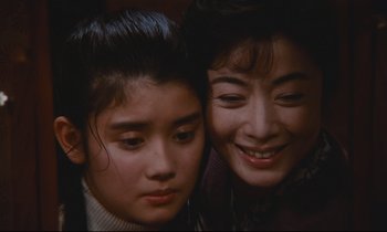Movie still from “Chizuko's Younger Sister” (1991), directed by Nobuhiko Ôbayashi – A woman and a young girl smiling for the camera; Close Up shot, Low angle