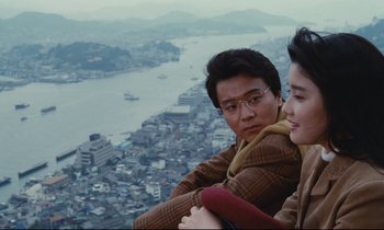 Movie still from “Chizuko's Younger Sister” (1991), directed by Nobuhiko Ôbayashi – A man and a woman sitting on top of a building; Medium shot, High angle