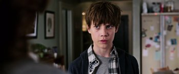 Movie still from “The Dark Tower” (2017), directed by Nikolaj Arcel – A young boy with short brown hair wearing a plaid shirt; Close Up shot, Over the shoulder angle