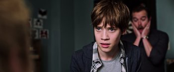 Movie still from “The Dark Tower” (2017), directed by Nikolaj Arcel – A young man with brown hair wearing a plaid shirt; Close Up shot, High angle