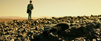 Movie still from “The Dark Tower” (2017), directed by Nikolaj Arcel – A pair of shoes sitting on top of a rock pile; Wide shot, Low angle