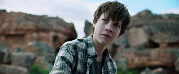 Movie still from “The Dark Tower” (2017), directed by Nikolaj Arcel – A young man in a checkered shirt looks into the distance; Close Up shot, Low angle