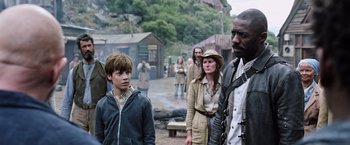 Movie still from “The Dark Tower” (2017), directed by Nikolaj Arcel – A group of people standing in the middle of a village; Medium shot, Over the shoulder angle