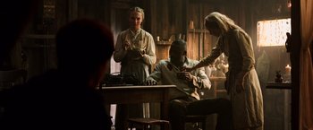 Movie still from “The Dark Tower” (2017), directed by Nikolaj Arcel – A man sitting at a table with two women; Medium shot, Over the shoulder angle