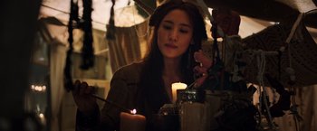 Movie still from “The Dark Tower” (2017), directed by Nikolaj Arcel – A woman sitting at a table with a lit candle; Close Up shot, Over the shoulder angle