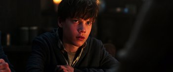 Movie still from “The Dark Tower” (2017), directed by Nikolaj Arcel – A young man is sitting in a dark room; Close Up shot, Low angle