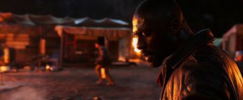 Movie still from “The Dark Tower” (2017), directed by Nikolaj Arcel – A person with a fire in the background; Close Up shot, Over the shoulder angle
