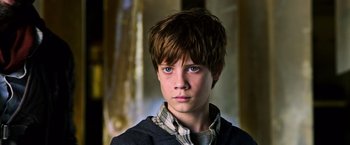 Movie still from “The Dark Tower” (2017), directed by Nikolaj Arcel – A young boy with blue eyes stares into the camera; Close Up shot, High angle