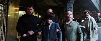 Movie still from “The Dark Tower” (2017), directed by Nikolaj Arcel – A group of people walking down a street; Medium shot, Over the shoulder angle