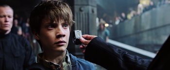 Movie still from “The Dark Tower” (2017), directed by Nikolaj Arcel – A young man holding a cell phone up to his face; Close Up shot, Over the shoulder angle