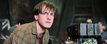 Movie still from “The Dark Tower” (2017), directed by Nikolaj Arcel – A young man with long brown hair wearing a plaid shirt; Close Up shot, Over the shoulder angle