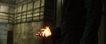 Movie still from “The Dark Tower” (2017), directed by Nikolaj Arcel – A man in a black suit is holding his hands out; Extreme Close Up shot, High angle