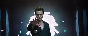 Movie still from “The Dark Tower” (2017), directed by Nikolaj Arcel – A man in a black shirt is holding his hand up; Medium shot, Low angle